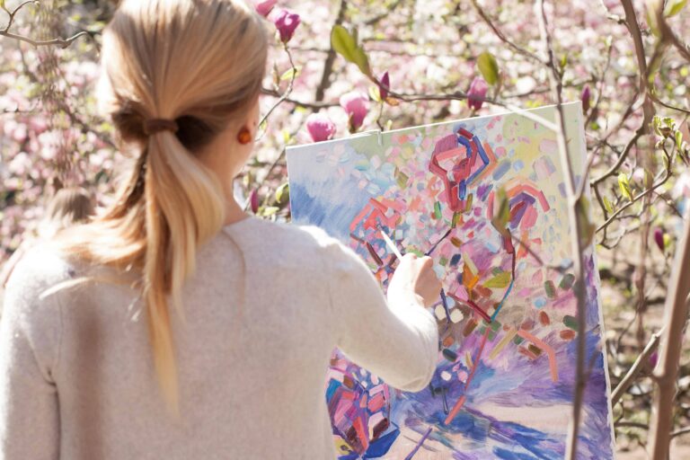 Woman painting on canvas outdoors